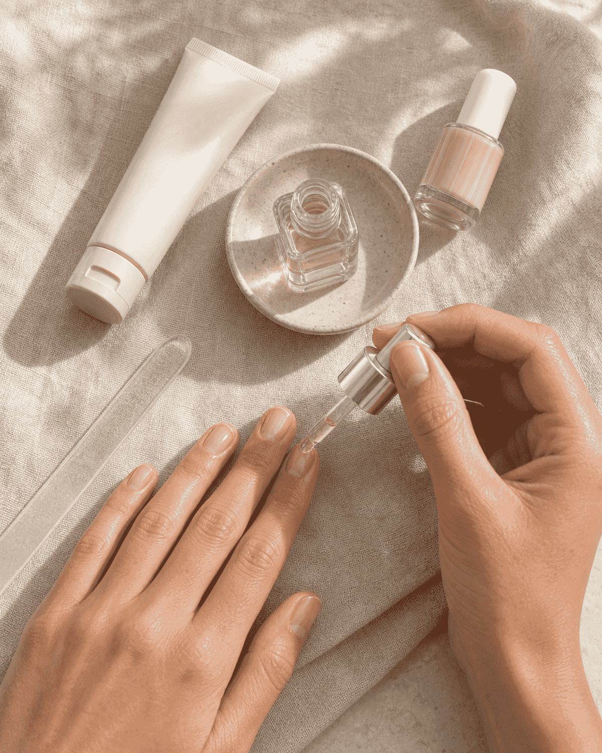 A nail file, hand cream, and sheer polish on a small tray.